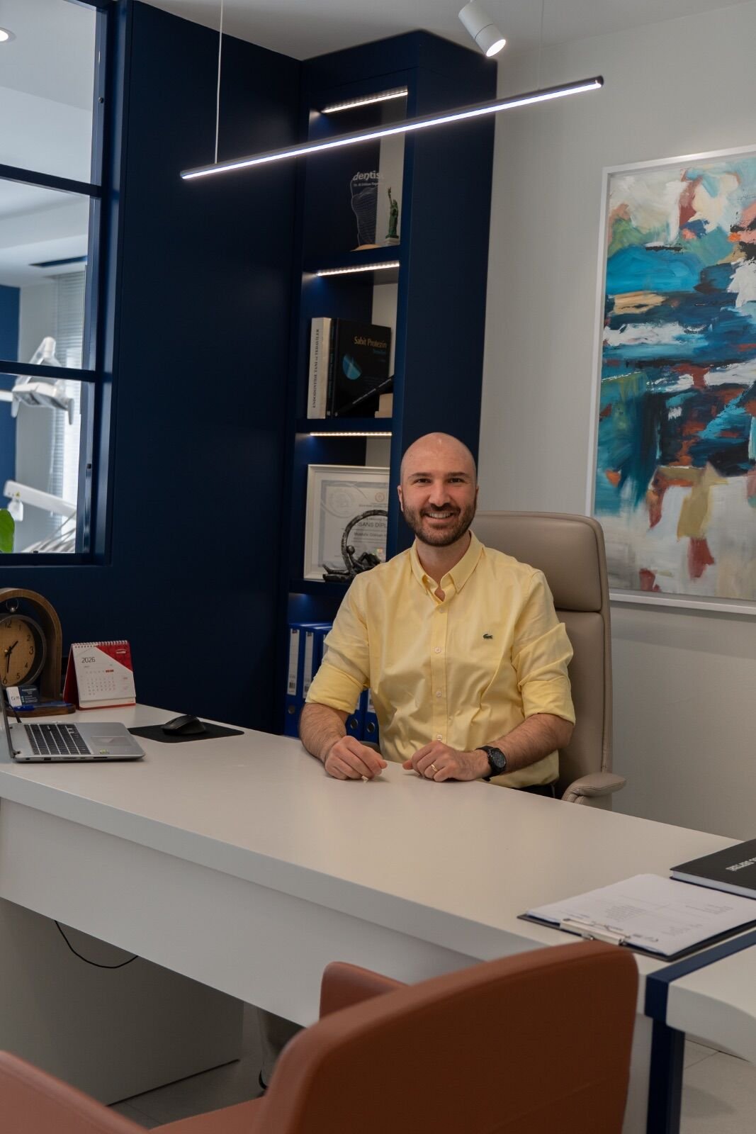 Dr. Koyuncu in the consultation room — the listen-first approach to dental treatment.